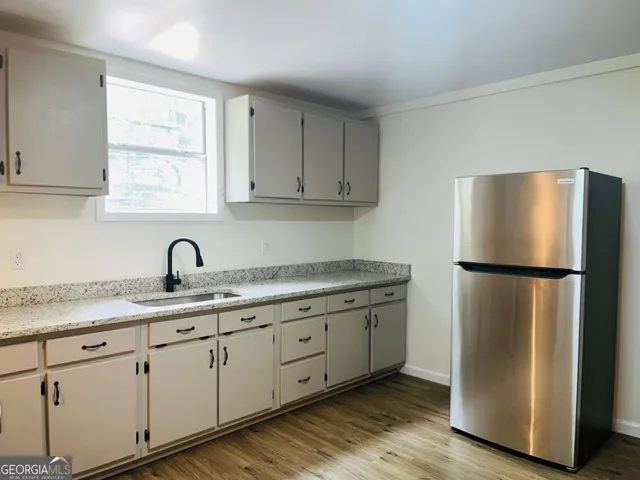 a kitchen with appliances a sink a refrigerator and window