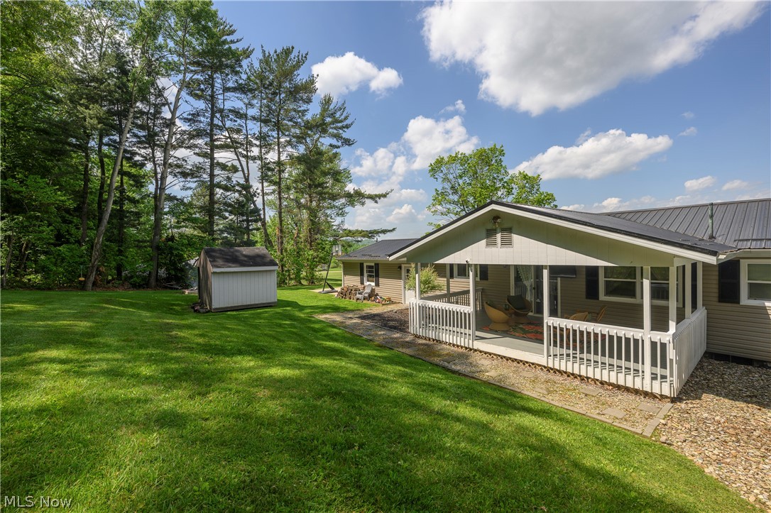 6105 Wolf Run Road Southeast Dennison, OH 44621 - Photo 11 of 35 Expansive green lawn featuring a storage shed and mature trees