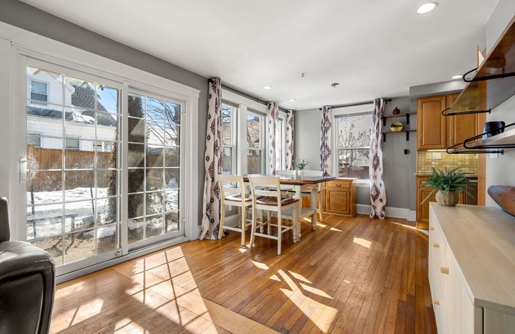 15 Lexington Terrace, Unit 1 Waltham, MA 02452 - Photo 8 of 13 a living room with furniture a dining table and a large window with garden view