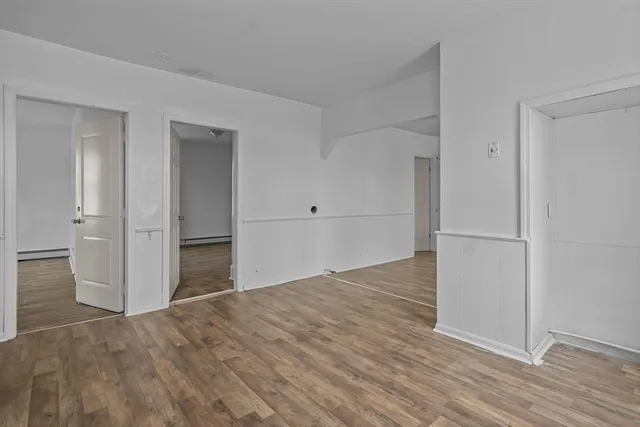 an empty room with wooden floor & closet and windows