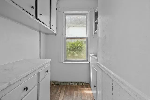 a utility room with wooden floor washer and dryer
