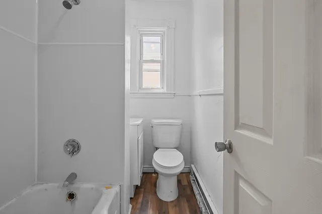 a white toilet sitting next to a bath tub