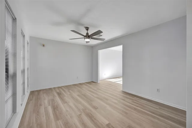 a view of a big room with wooden floor and windows