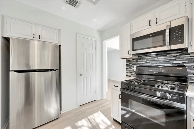 a kitchen with stainless steel appliances a refrigerator stove and microwave