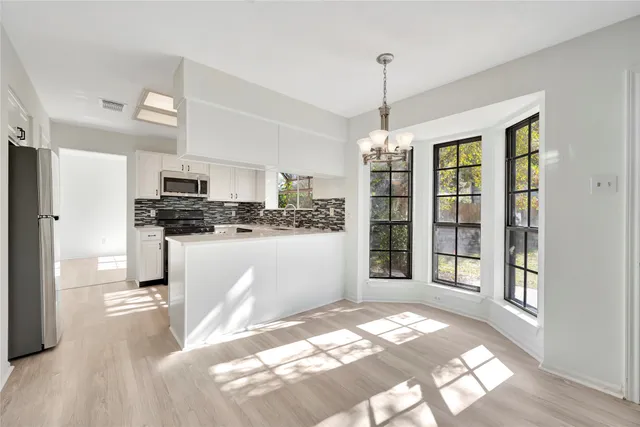 a kitchen with kitchen island granite countertop a refrigerator stove top oven and sink