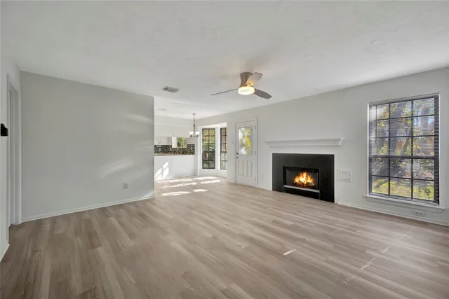 a view of an empty room with a fireplace and a window
