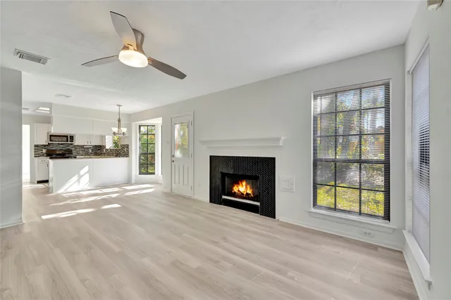 a view of an empty room with a window and fireplace
