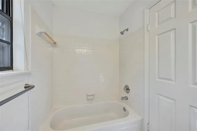 a white bath tub sitting next to a shower