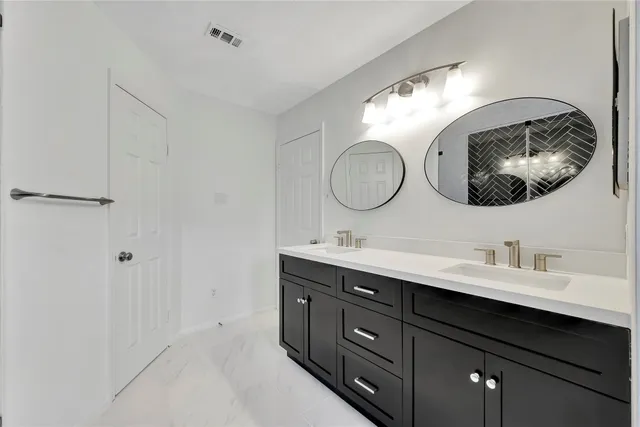 a bathroom with a double vanity sink and a mirror