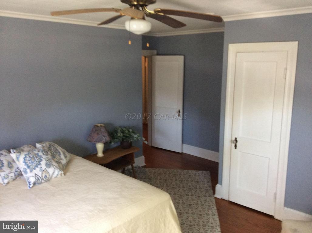 20502 Nanticoke Road Nanticoke, MD 21840 - Photo 20 of 27 a bedroom with a bed and a chandelier