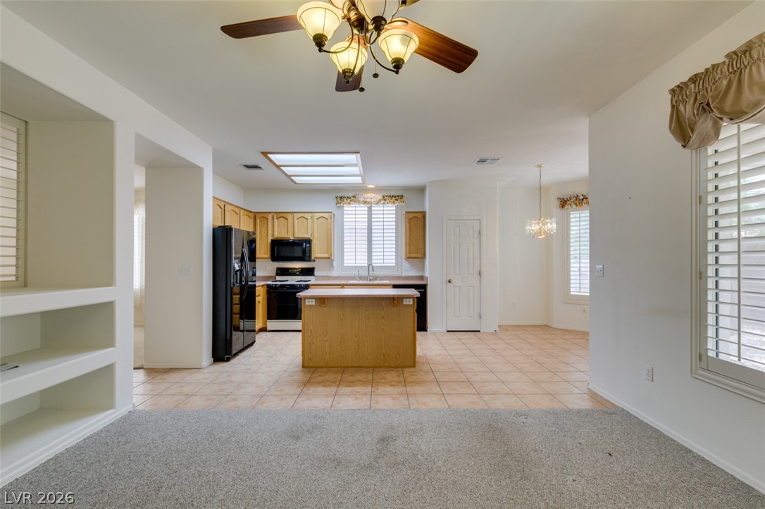 2189 Chapman Ranch Drive Henderson, NV 89012 - Photo 21 of 60 An open layout connects the tile-floored kitchen with a carpeted living space.