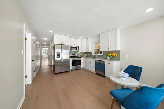 a kitchen with stainless steel appliances kitchen island a refrigerator sink and cabinets