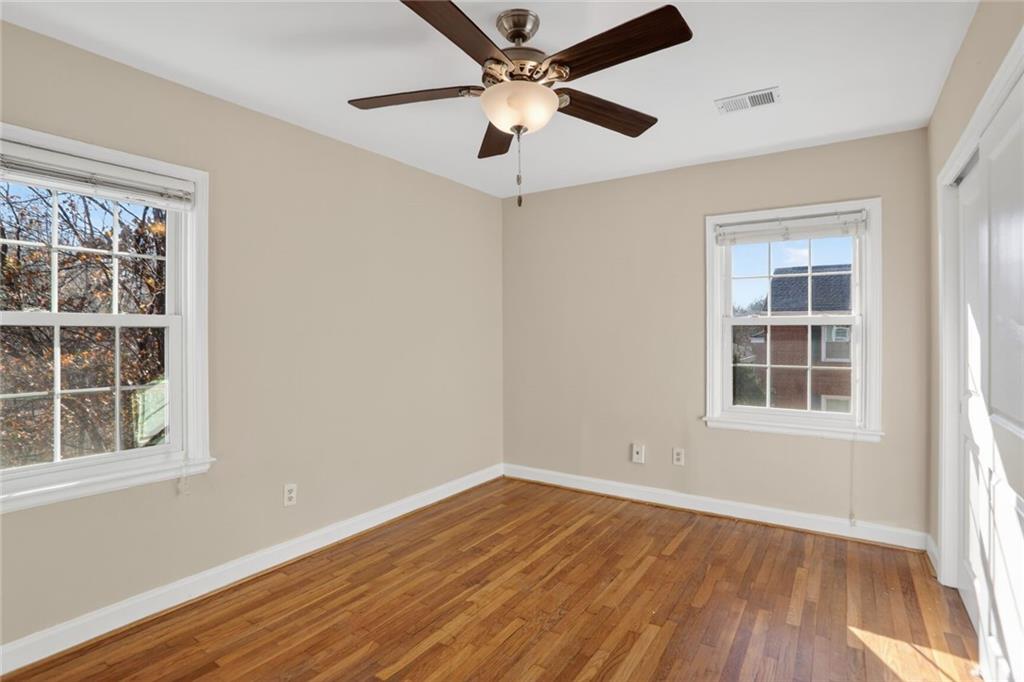 578 Goldsboro Road Northeast, Unit D Atlanta, GA 30307 - Photo 12 of 20 an empty room with wooden floor chandelier fan and windows