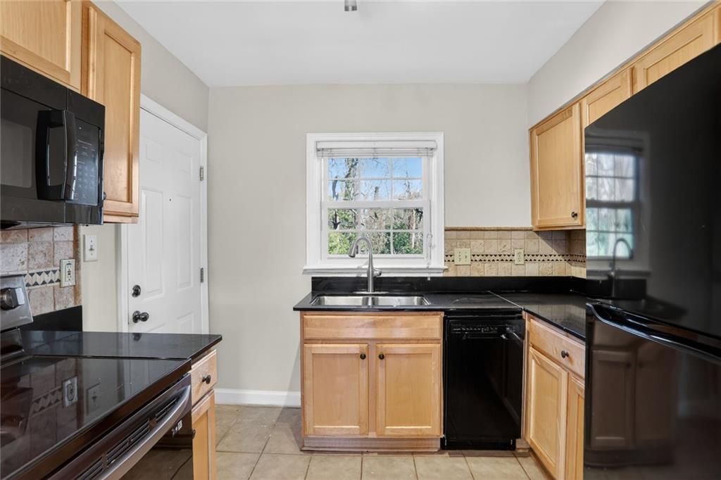 578 Goldsboro Road Northeast, Unit D Atlanta, GA 30307 - Photo 7 of 20 a kitchen with granite countertop a sink stove and cabinets