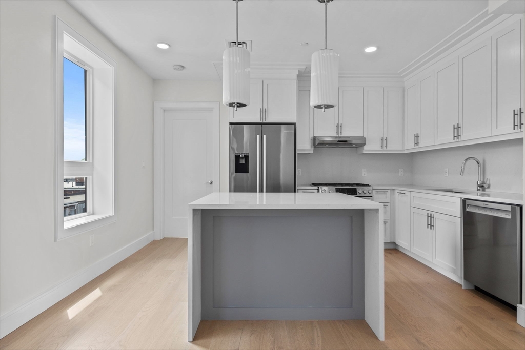 301 Border Street, Unit PH3 Boston, MA 02128 - Photo 3 of 17 a kitchen with stainless steel appliances granite countertop a sink stove and refrigerator