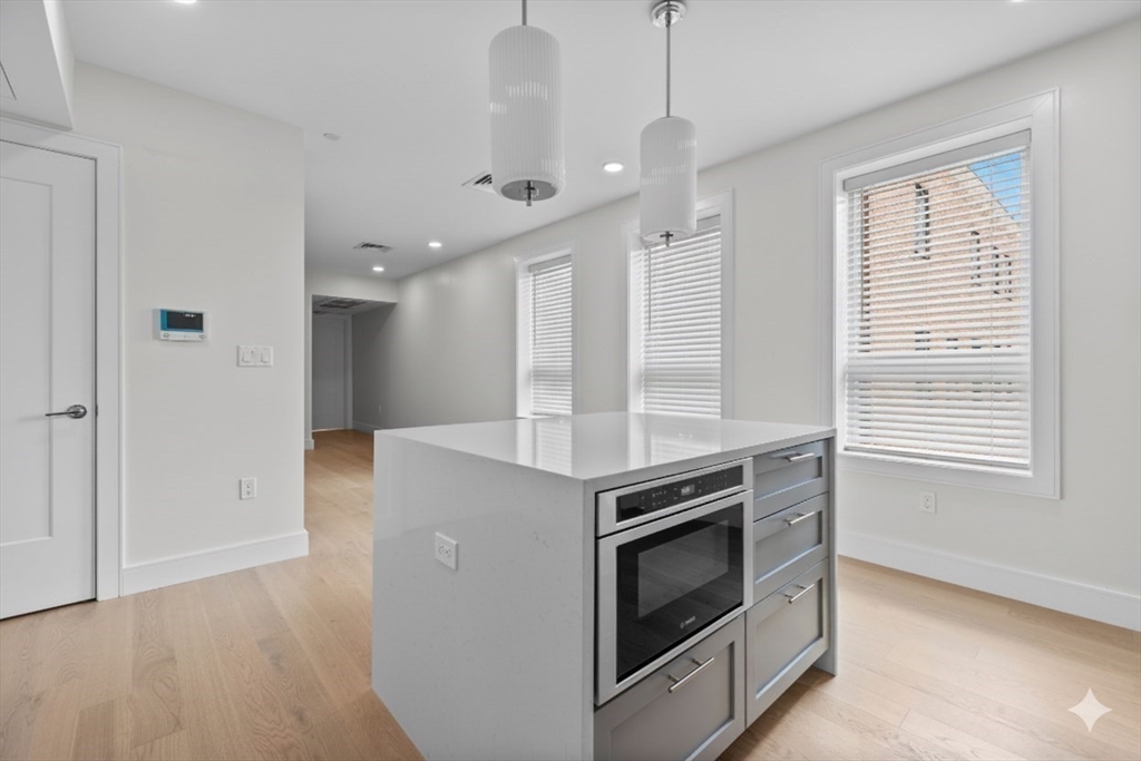 301 Border Street, Unit PH3 Boston, MA 02128 - Photo 4 of 17 a kitchen with stainless steel appliances granite countertop a stove and a refrigerator