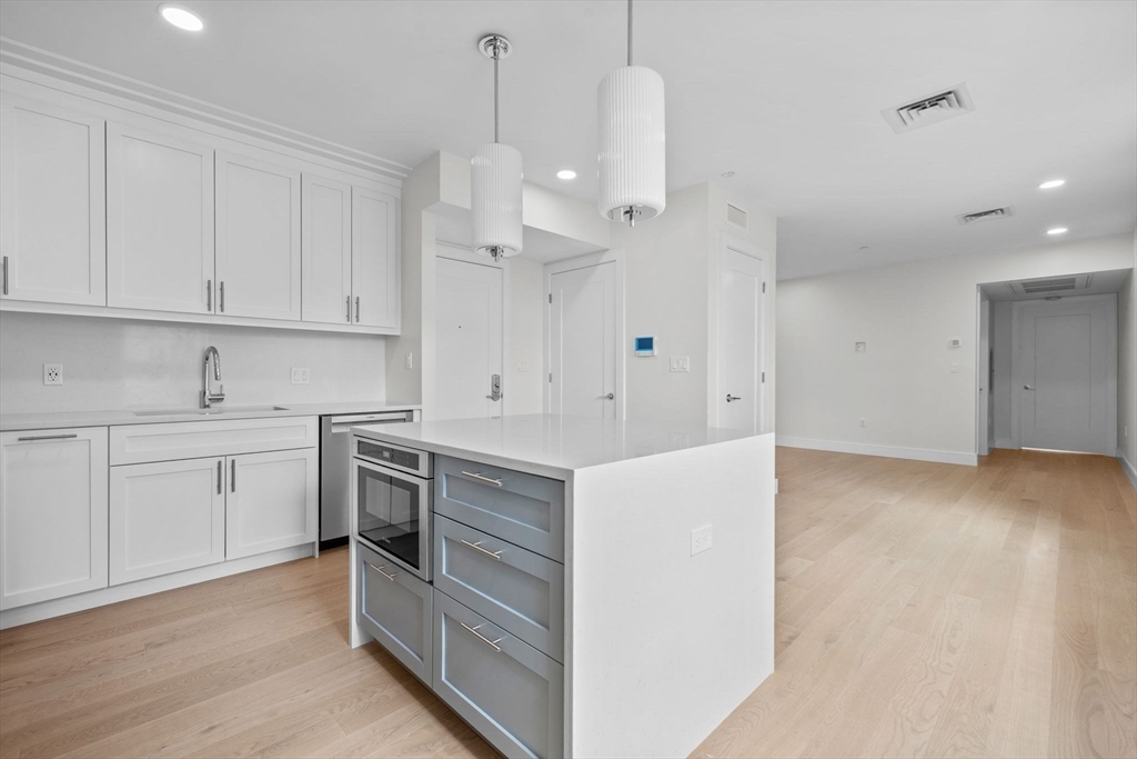 301 Border Street, Unit PH3 Boston, MA 02128 - Photo 6 of 17 a kitchen with white cabinets and sink
