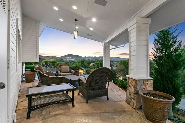 a view of a patio with table and chairs and floor to ceiling window