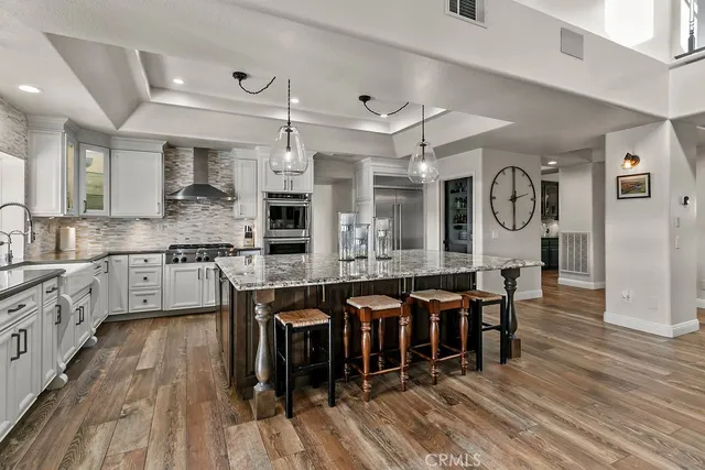 a view of a dining room with furniture large windows a chandelier and wooden floor