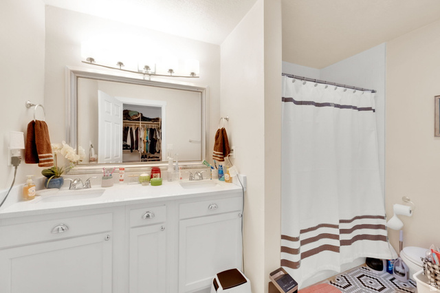 501 Canyon Road Ogden, UT 84404 - Photo 11 of 30 Dual vanity with chrome fixtures and ample counter space, complemented by a large framed mirror with overhead lighting