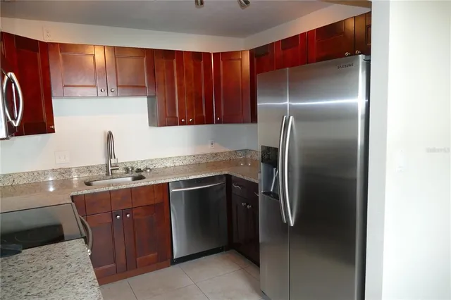 a kitchen with stainless steel appliances granite countertop a sink stove and refrigerator