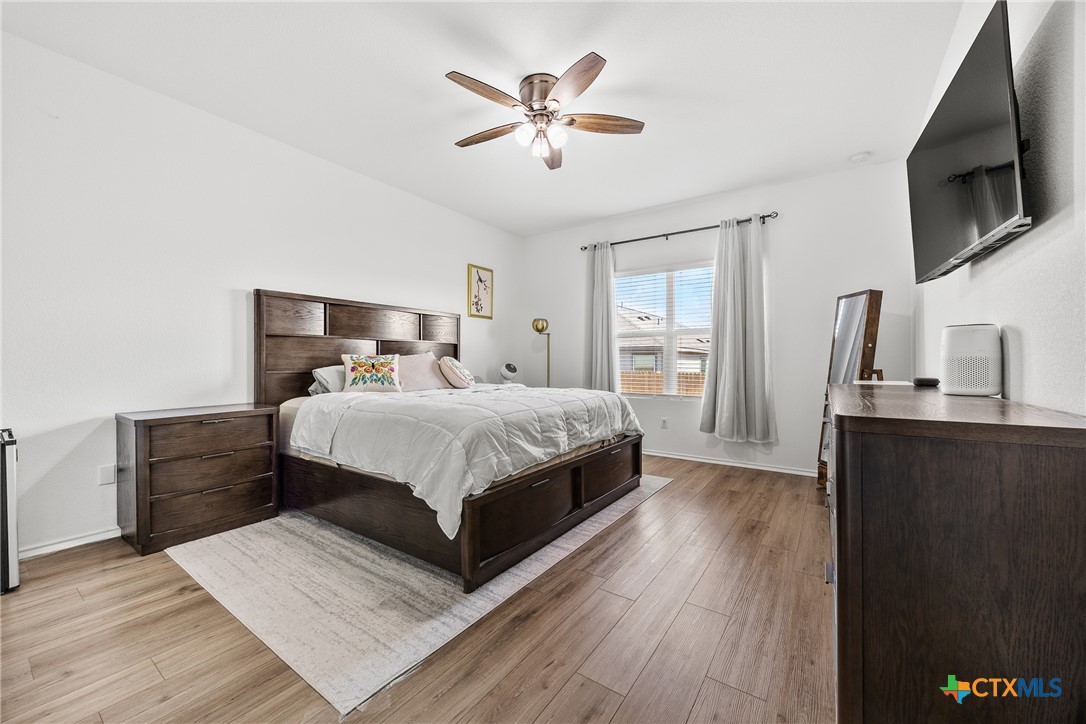 141 Rowdy Yates Way Jarrell, TX 76537 - Photo 13 of 32 a bedroom with a large bed a flat tv screen and dresser