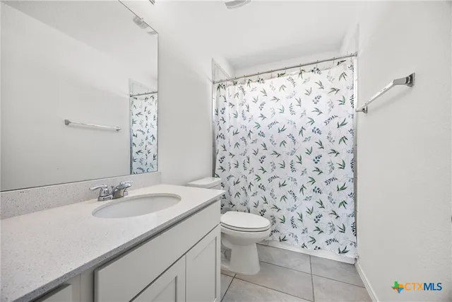 a bathroom with a granite countertop sink a toilet and a mirror