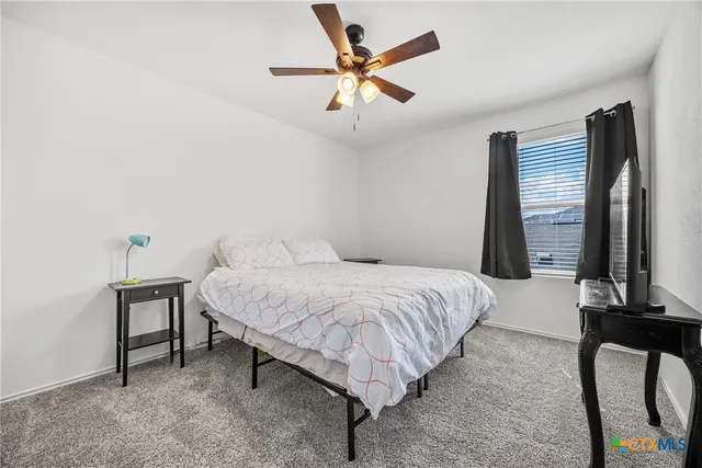 a bedroom with a bed desk and a window