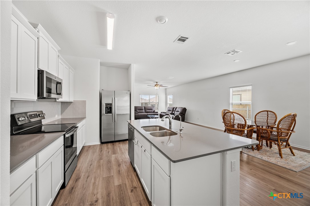 141 Rowdy Yates Way Jarrell, TX 76537 - Photo 6 of 32 a kitchen with granite countertop cabinets a sink a counter space and stainless steel appliances