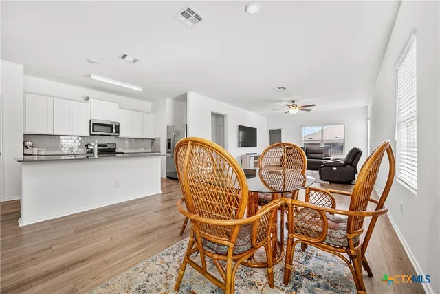a view of a dining room with furniture kitchen and wooden floor