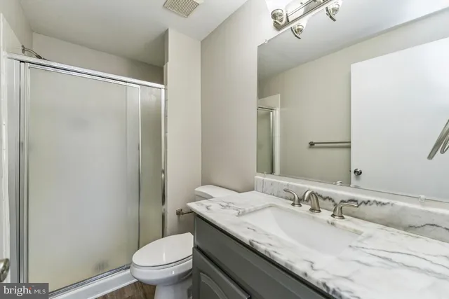 a view of a livingroom with wooden floor and a ceiling fan