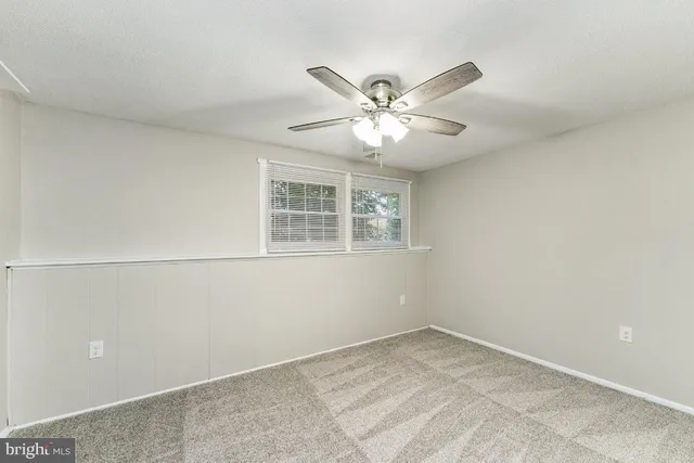 a view of a big room with wooden floor and a chandelier fan