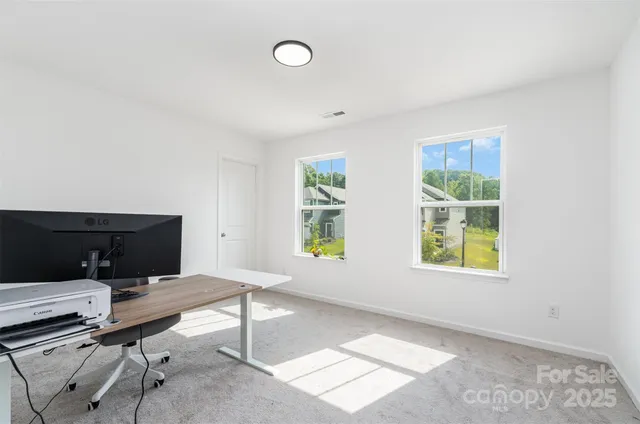 a view of a workspace with furniture and a window