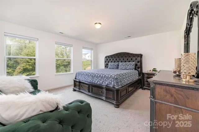 a bedroom with a bed and a view of kitchen