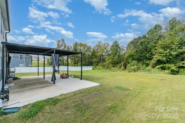 a view of a house with a big yard and large trees
