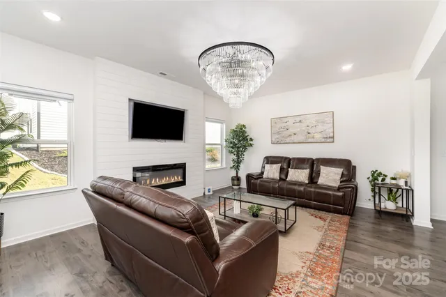 a living room with furniture a chandelier and a flat screen tv