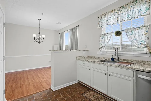 a kitchen with granite countertop white cabinets and stainless steel appliances