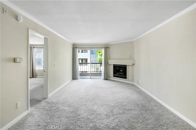 an empty room with windows and fireplace