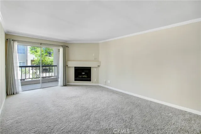 a view of an empty room with a fireplace and a window