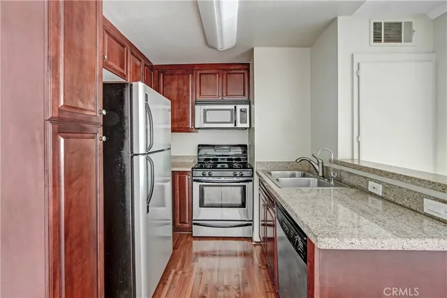 a kitchen with stainless steel appliances granite countertop a refrigerator and a sink