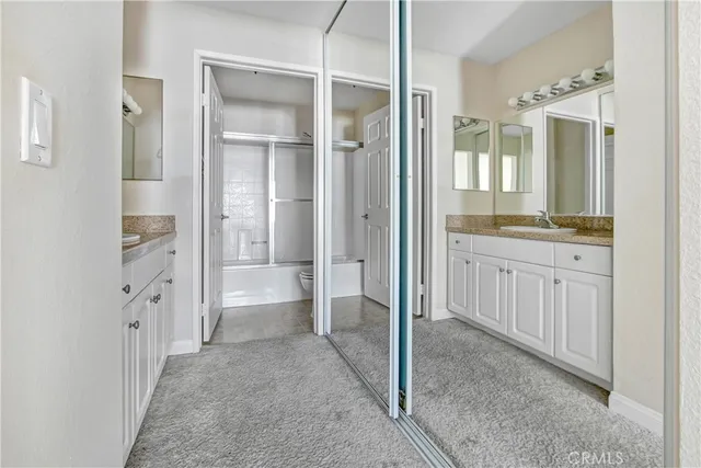 a bathroom with a glass door shower a sink and a mirror