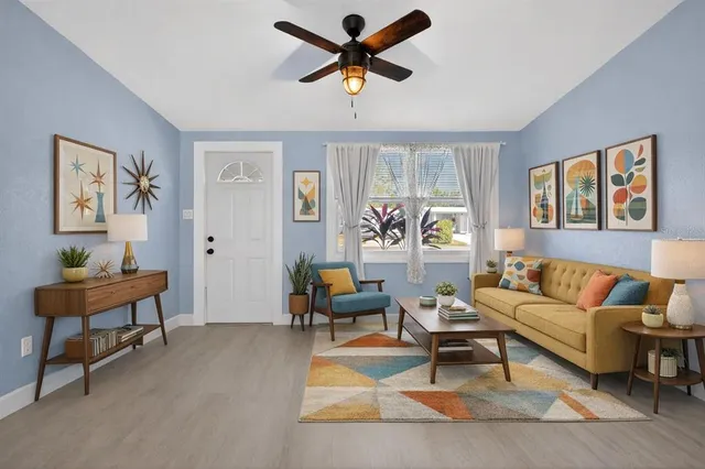 a living room with furniture a table and a large window