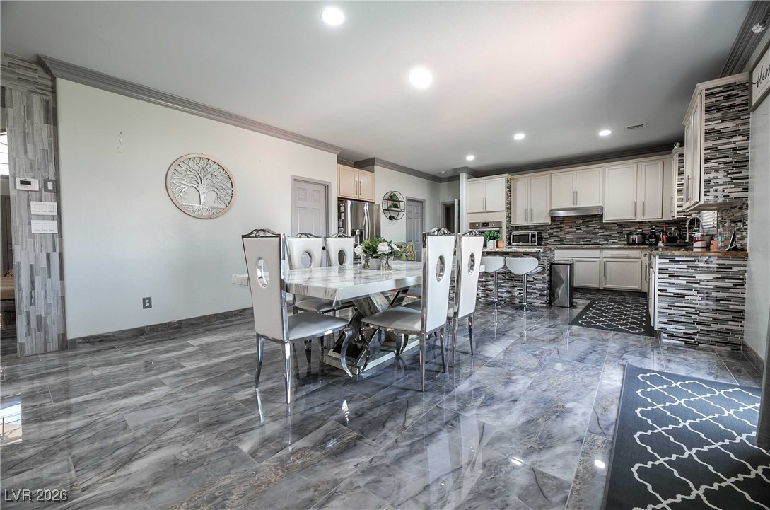 418 Finch Ridge Avenue North Las Vegas, NV 89032 - Photo 13 of 38 Dining space featuring crown molding, dark marble finish floors, and recessed lighting