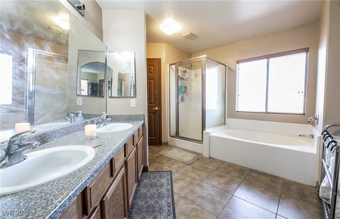 418 Finch Ridge Avenue North Las Vegas, NV 89032 - Photo 20 of 38 Bathroom with a garden tub, double vanity, a stall shower, and light tile patterned flooring