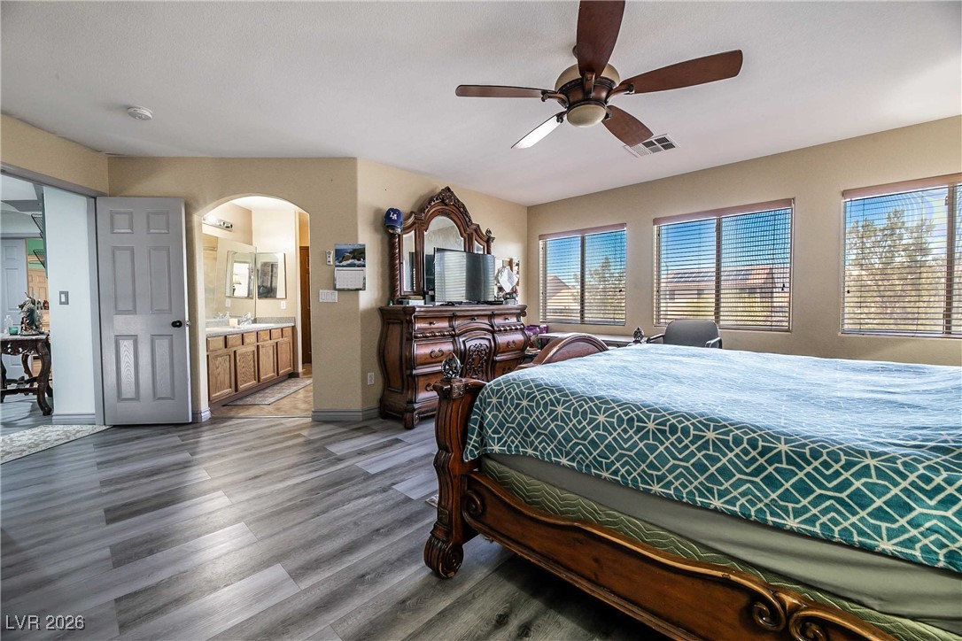 418 Finch Ridge Avenue North Las Vegas, NV 89032 - Photo 22 of 43 Bedroom featuring dark wood-style flooring, a ceiling fan, arched walkways, and ensuite bathroom