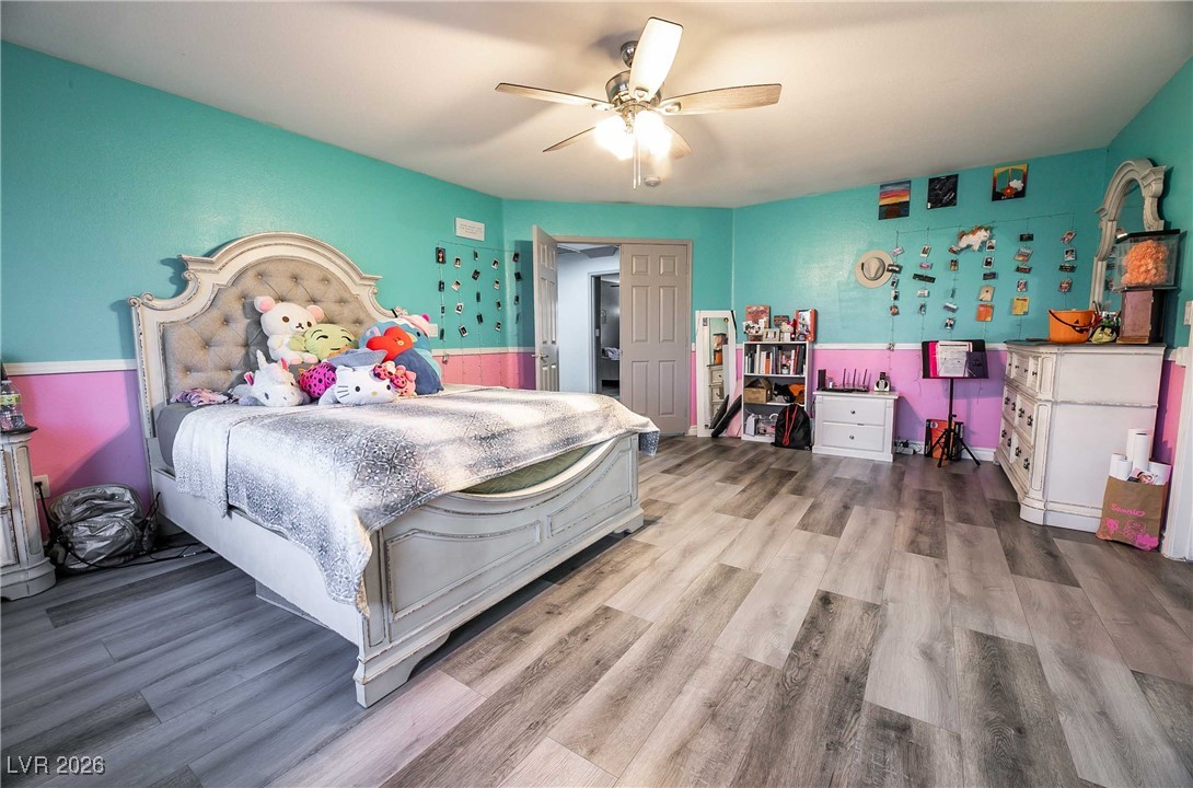 418 Finch Ridge Avenue North Las Vegas, NV 89032 - Photo 29 of 38 Bedroom featuring wood finished floors, a ceiling fan, and wainscoting