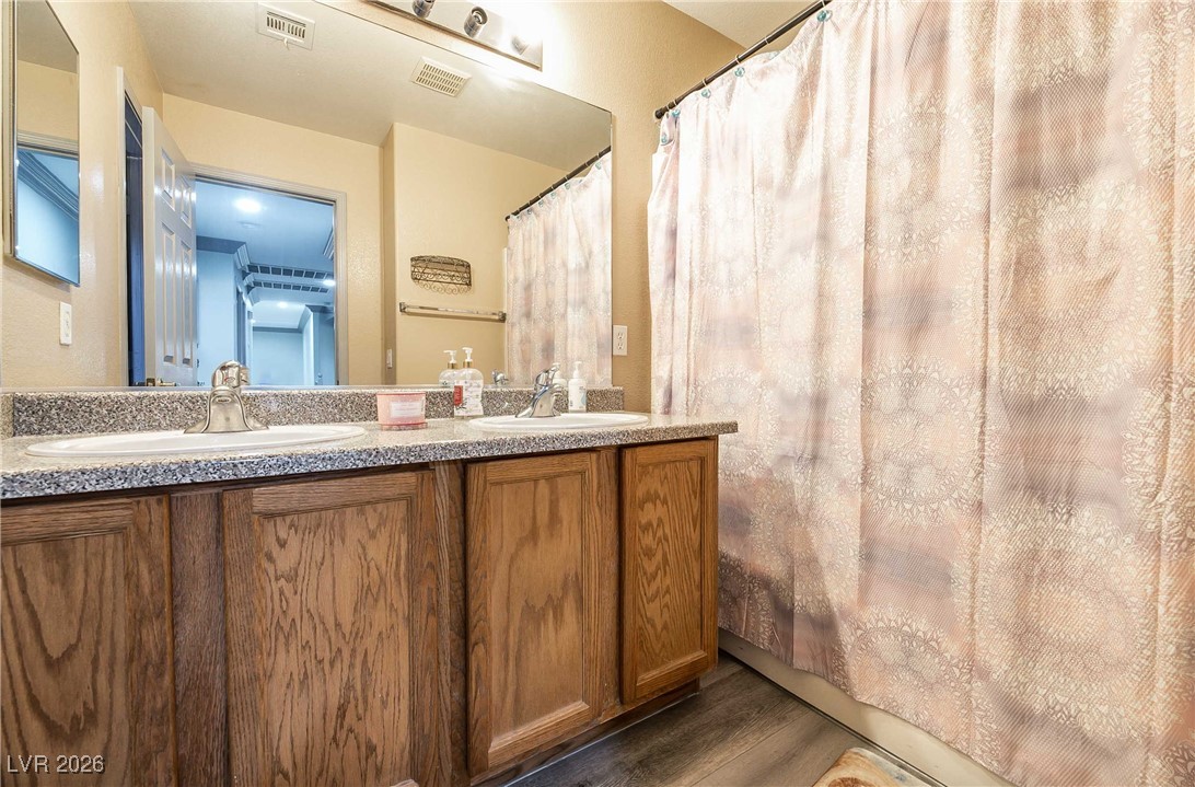 418 Finch Ridge Avenue North Las Vegas, NV 89032 - Photo 35 of 43 Bathroom featuring a shower with shower curtain, double vanity, and dark wood-type flooring
