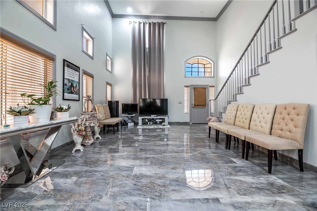 418 Finch Ridge Avenue North Las Vegas, NV 89032 - Photo 7 of 38 Foyer entrance featuring marble tiled floors, plenty of natural light, a high ceiling, ornamental molding, and stairway