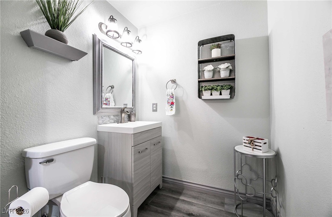 418 Finch Ridge Avenue North Las Vegas, NV 89032 - Photo 9 of 38 Half bathroom with a textured wall, vanity, and dark wood finished floors
