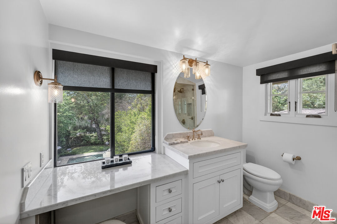 760 South San Rafael Avenue Pasadena, CA 91105 - Photo 32 of 45 a bathroom with a toilet sink a mirror and next to a window